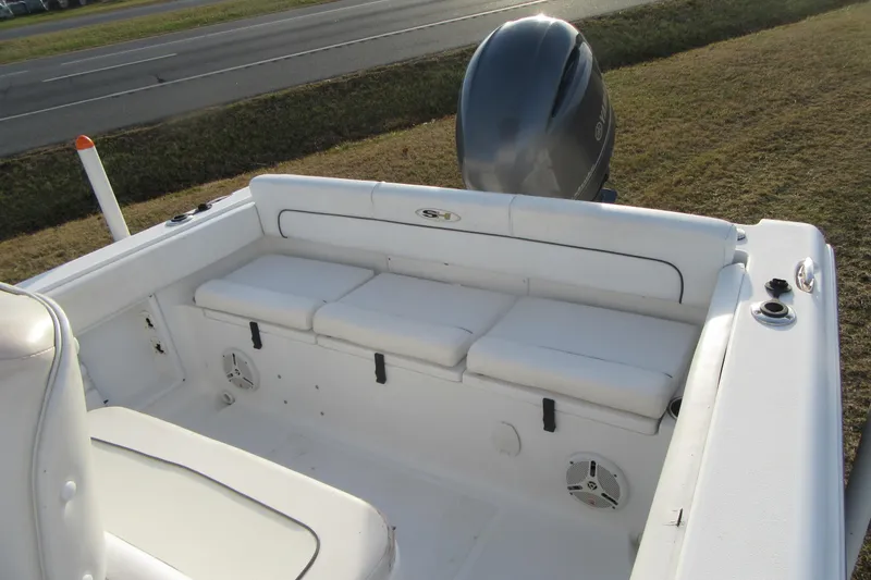 Slide: The Image of 2014 Sea Hunt Ultra 234 boat interior with cushioned seating and outboard motor. - 27