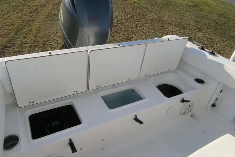 Slide: The Image of 2014 Sea Hunt Ultra 234 boat interior with storage compartments and engine view. - 32