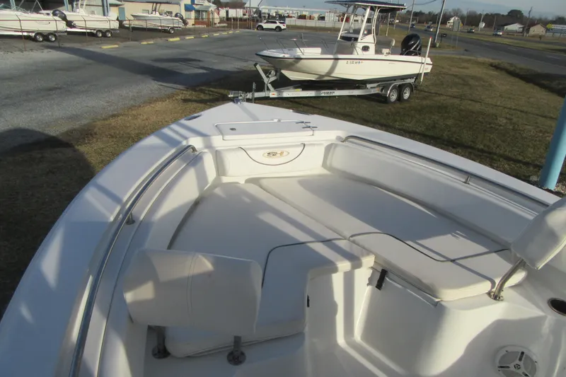 Slide: The Image of 2014 Sea Hunt Ultra 234 boat with spacious seating, parked outdoors. - 7