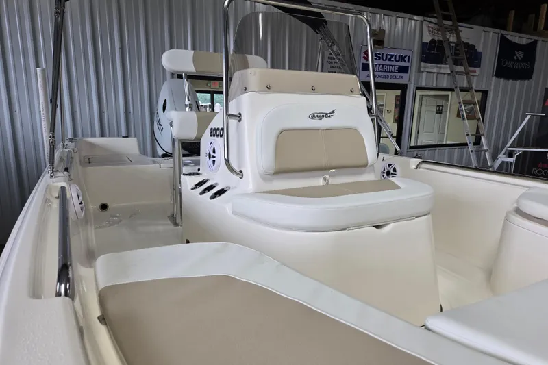 Slide: The Image of 2026 Bulls Bay 2000 boat interior with seating and console, displayed in a showroom. - 14