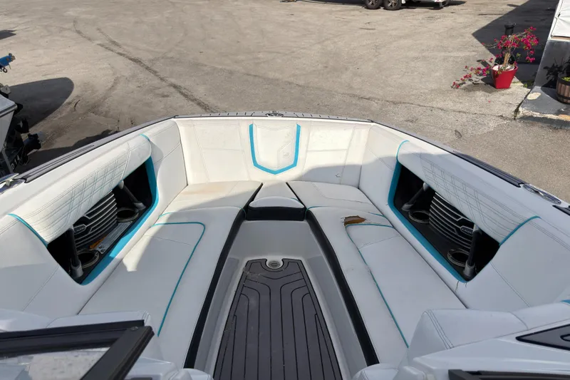 Slide: The Image of 2018 Nautique Super Air Nautique G25 Coastal Edition boat interior with white seating and blue accents. - 11