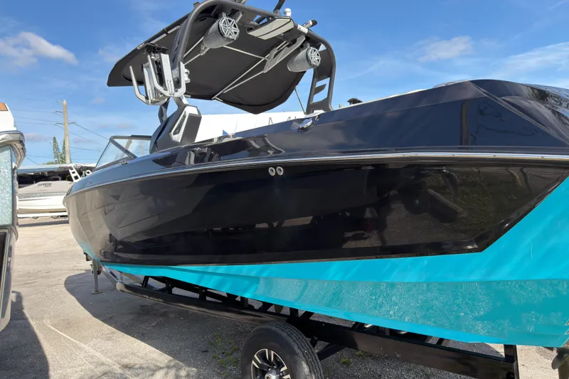 Slide: The Image of 2018 Nautique Super Air Nautique G25 Coastal Edition boat on trailer, black and blue design. - 3