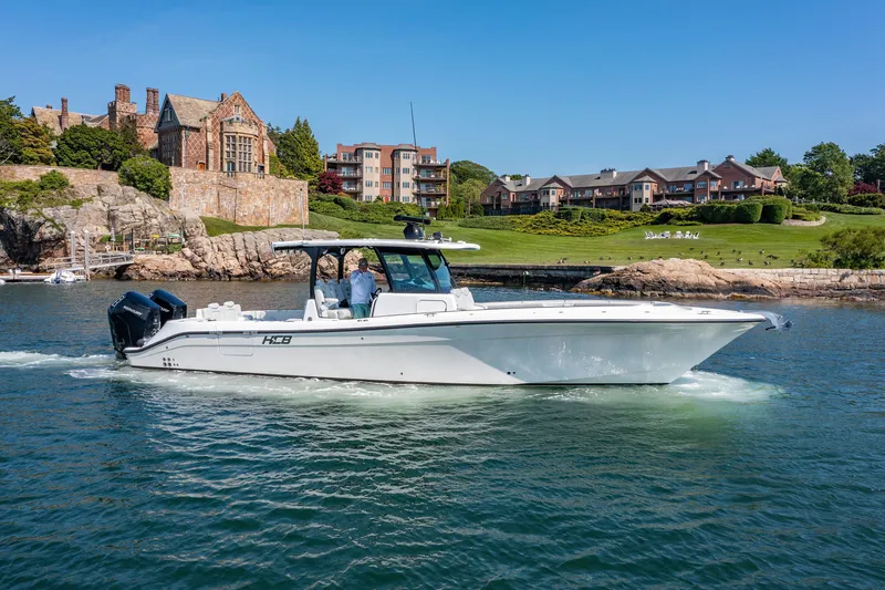 Slide: The Image of 2024 HCB 39 Speciale boat cruising near waterfront homes. - 42