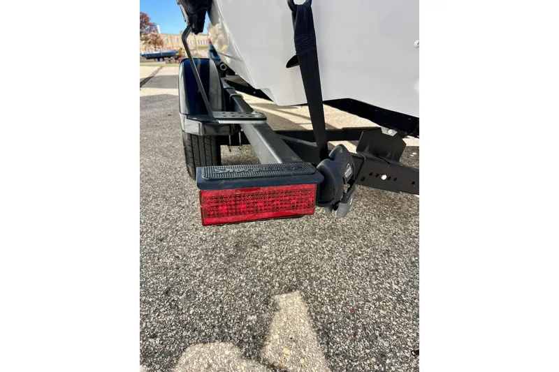 Slide: The Image of 2024 Crestliner 1650 Fish Hawk SC trailer with red tail light on asphalt. - 11