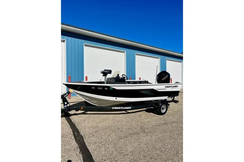 Slide: The Image of 2024 Crestliner 1650 Fish Hawk SC boat on trailer, parked outside blue building. - 60