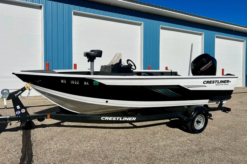 Slide: The Image of 2024 Crestliner 1650 Fish Hawk SC boat on trailer, parked outside blue building. - 61