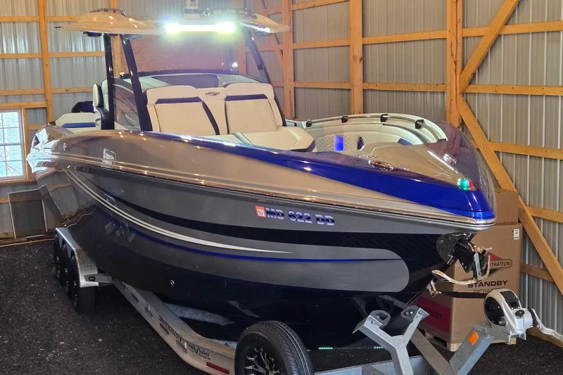 Slide: The Image of 2021 Sunsation 34 CCX boat in storage, featuring sleek design and vibrant blue accents. - 25