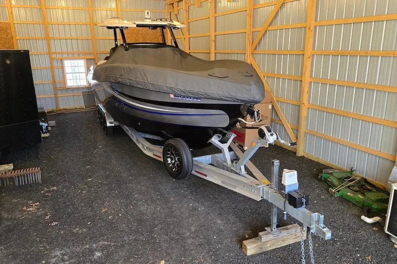 Slide: The Image of 2021 Sunsation 34 CCX boat covered and stored in a wooden garage on a trailer. - 38