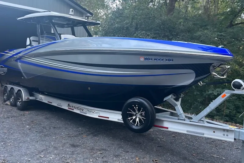 Slide: The Image of 2021 Sunsation 34 CCX boat on trailer, sleek design, blue and silver color scheme. - 4