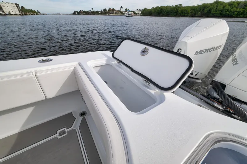 Slide: The Image of 2022 Freeman 42LR boat with open storage compartment and Mercury outboard engines on a calm waterway. - 33