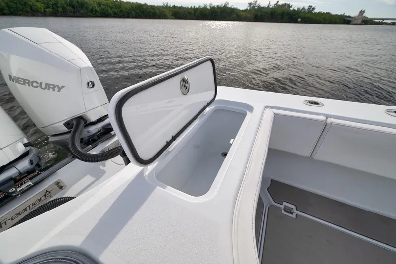 Slide: The Image of 2022 Freeman 42LR boat with Mercury engine, open storage compartment, on calm water. - 34