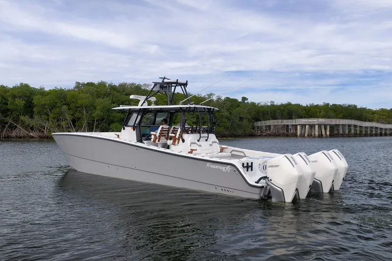 Slide: The Image of 2022 Freeman 42LR boat with quad Mercury engines on a calm waterway. - 4