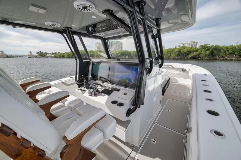 Slide: The Image of 2022 Freeman 42LR boat interior with modern helm, luxurious seating, and scenic waterway view. - 46