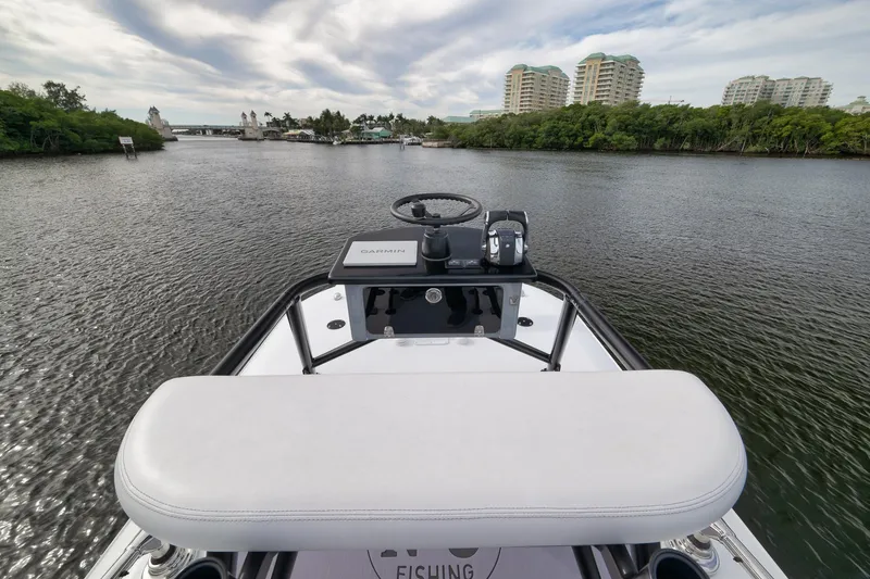 Slide: The Image of 2022 Freeman 42LR boat navigating a scenic river with modern buildings in the background. - 54