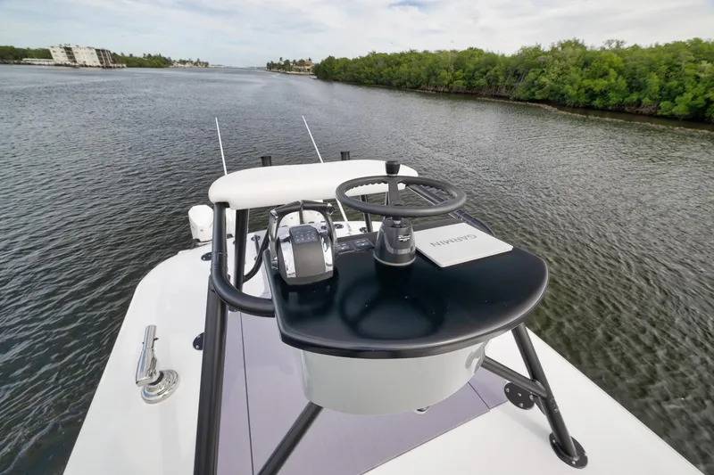 Slide: The Image of 2022 Freeman 42LR boat helm with Garmin navigation, cruising on a scenic waterway. - 56