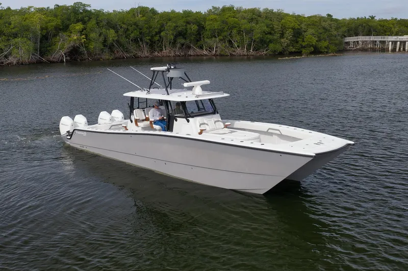 Slide: The Image of 2022 Freeman 42LR boat cruising on a calm river with lush green trees. - 6