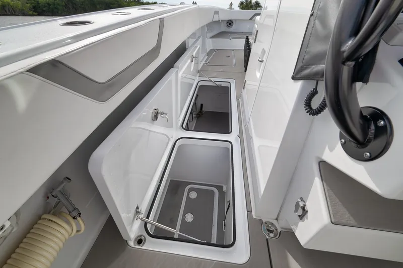 Slide: The Image of Freeman 42LR 2022 boat interior with open storage compartments and steering wheel. - 63