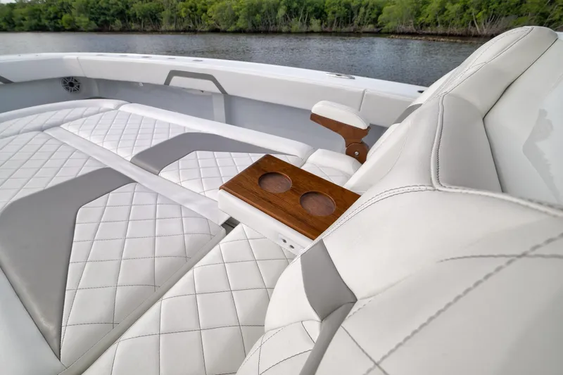 Slide: The Image of Luxurious seating on 2022 Freeman 42LR boat with quilted upholstery and wooden cup holders. - 70