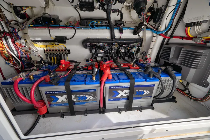 Slide: The Image of Battery compartment of a 2022 Freeman 42LR boat, featuring AGM batteries and wiring. - 77