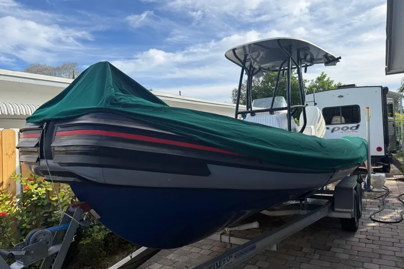Slide: The Image of 1998 Novamarine SEVEN HD boat with green cover on trailer, parked outdoors. - 23