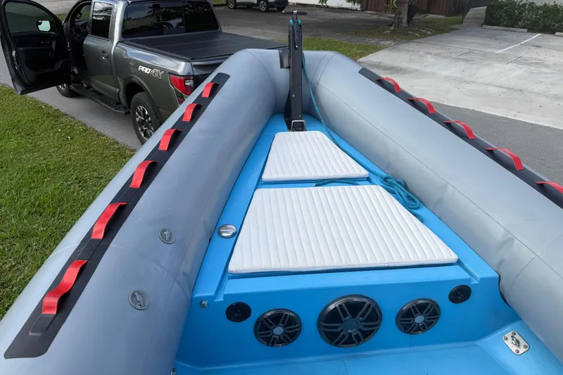 Slide: The Image of 1998 Novamarine SEVEN HD inflatable boat with padded seats, parked near a pickup truck. - 6