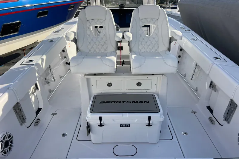 Slide: The Image of 2026 Sportsman Heritage 261 Center Console boat interior with white seating and Yeti cooler. - 10