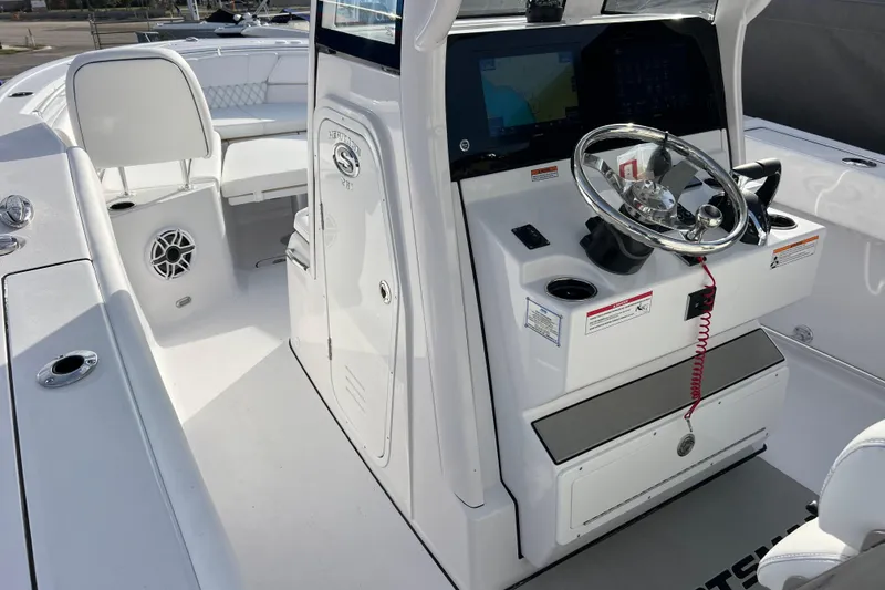 Slide: The Image of 2026 Sportsman Heritage 261 Center Console boat interior with steering wheel and seating. - 11