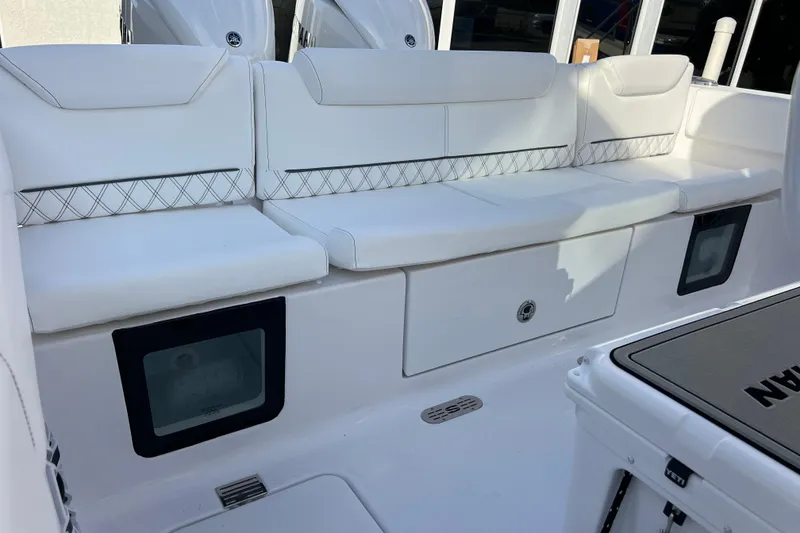 Slide: The Image of 2026 Sportsman Heritage 261 Center Console boat with white cushioned seating and storage compartments. - 23