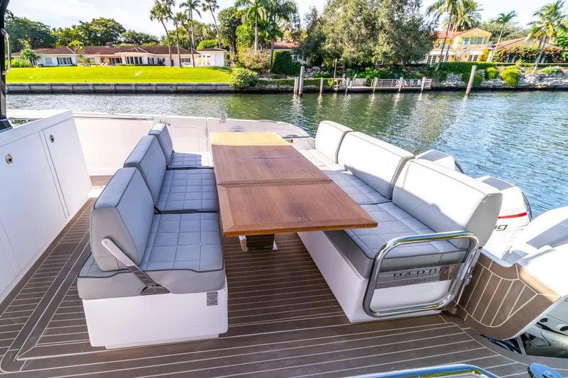 Slide: The Image of 2024 Pardo Yachts 38 interior with seating and table, docked by waterfront homes. - 21