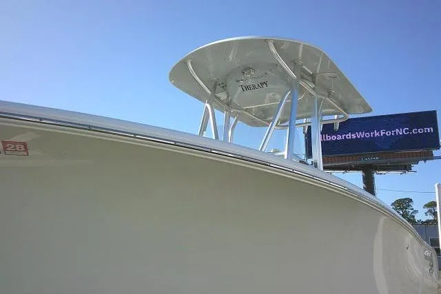 Slide: The Image of 2023 Sea Hunt Ultra 234 boat with T-top against clear blue sky. - 13