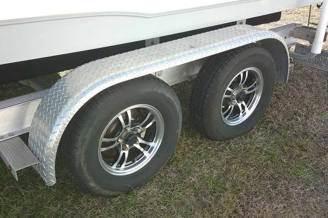 Slide: The Image of Trailer wheels of a 2023 Sea Hunt Ultra 234 boat on grass. - 14