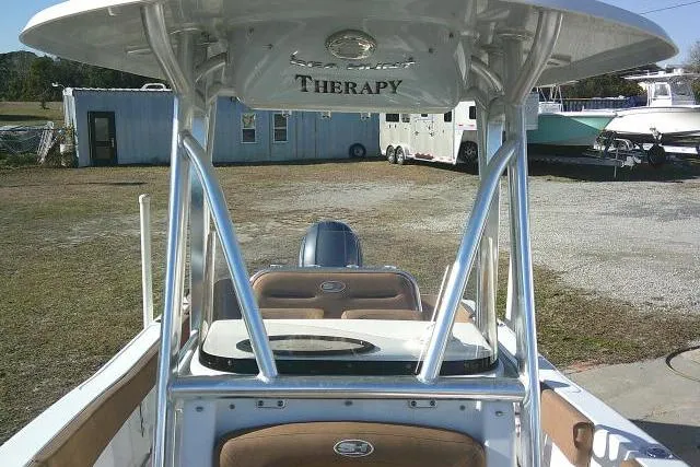 Slide: The Image of 2023 Sea Hunt Ultra 234 boat with "Therapy" name, parked outdoors. - 19
