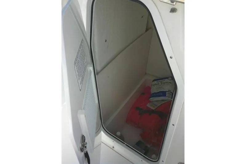 Slide: The Image of Storage compartment in 2023 Sea Hunt Ultra 234 boat with life jacket and supplies. - 22