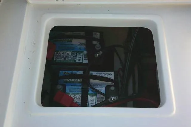 Slide: The Image of 2023 Sea Hunt Ultra 234 boat battery compartment with visible wiring. - 29