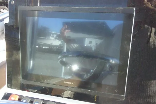 Slide: The Image of Garmin display on 2023 Sea Hunt Ultra 234 boat dashboard, reflecting outdoor scene. - 37