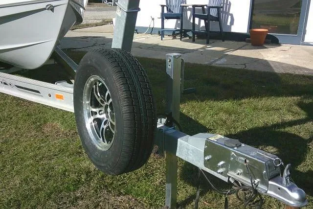 Slide: The Image of Trailer for 2023 Sea Hunt Ultra 234 boat with spare tire on grass. - 4