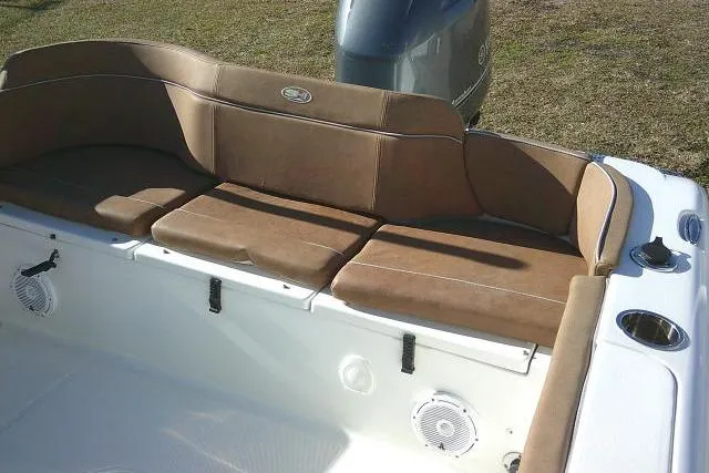 Slide: The Image of 2023 Sea Hunt Ultra 234 boat interior with brown cushioned seating and speakers. - 40