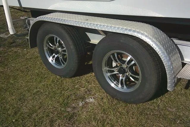 Slide: The Image of Trailer wheels of 2023 Sea Hunt Ultra 234 boat on grass. - 6