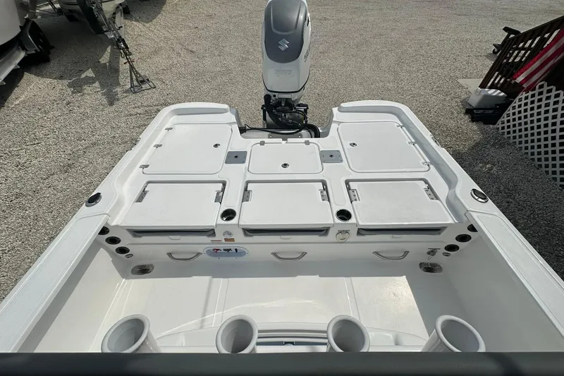 Slide: The Image of 2024 NauticStar 274 Bay boat deck with storage compartments and motor, viewed from above. - 10