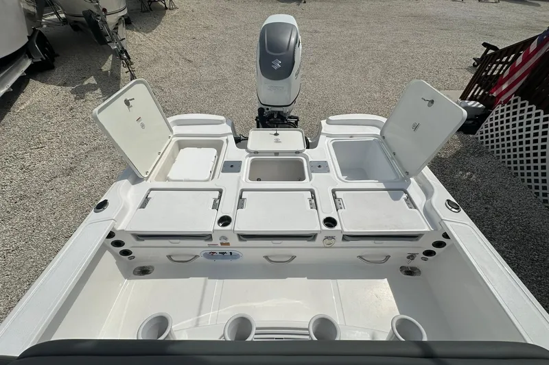 Slide: The Image of 2024 NauticStar 274 Bay boat with open storage compartments and Suzuki outboard motor. - 11
