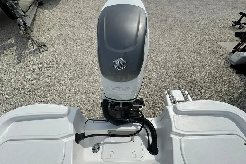 Slide: The Image of 2024 NauticStar 274 Bay boat with Suzuki outboard motor, rear view. - 12