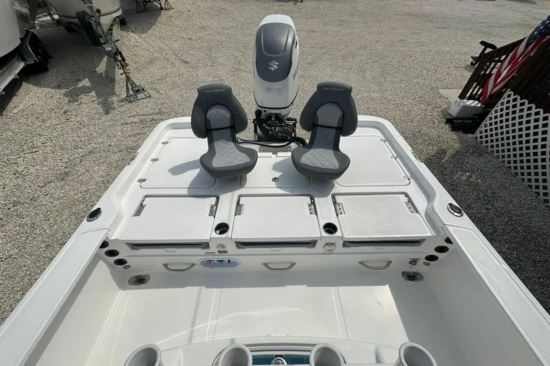 Slide: The Image of 2024 NauticStar 274 Bay boat with dual seats and outboard motor. - 14