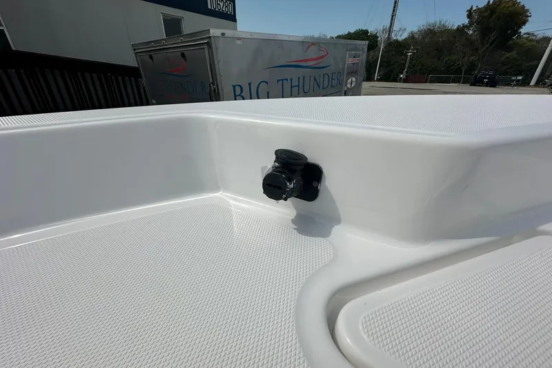 Slide: The Image of 2024 NauticStar 274 Bay boat deck with a black fitting, Big Thunder sign in background. - 16