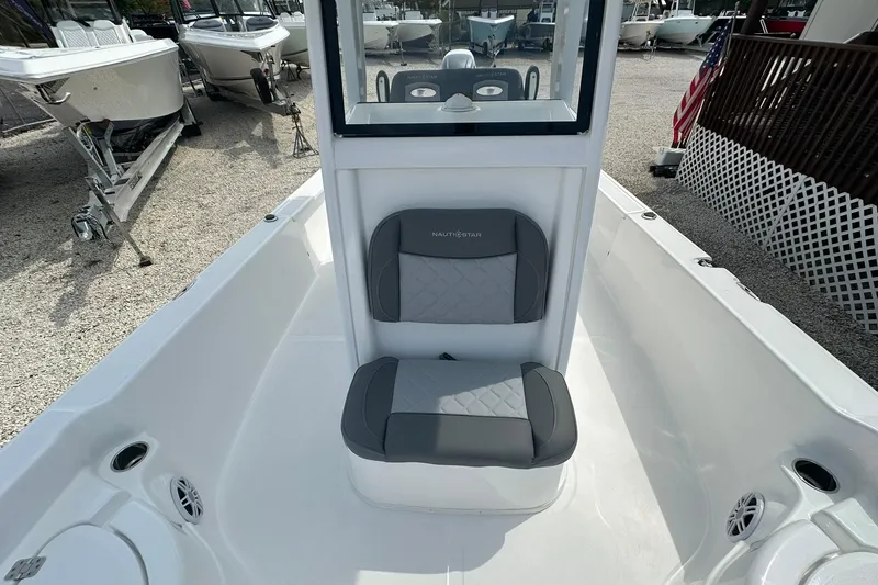 Slide: The Image of 2024 NauticStar 274 Bay boat interior with cushioned seating and console. - 17