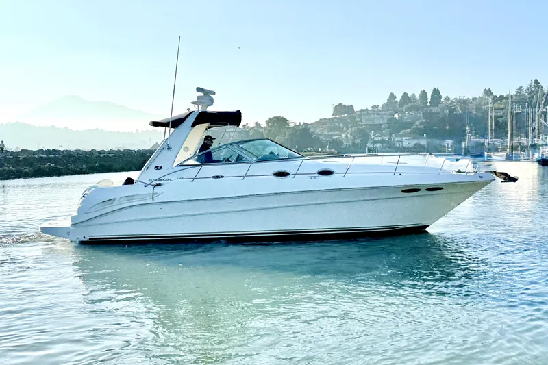 Slide: The Image of 2001 Sea Ray 340 Sundancer yacht cruising on calm waters near a scenic shoreline. - 4