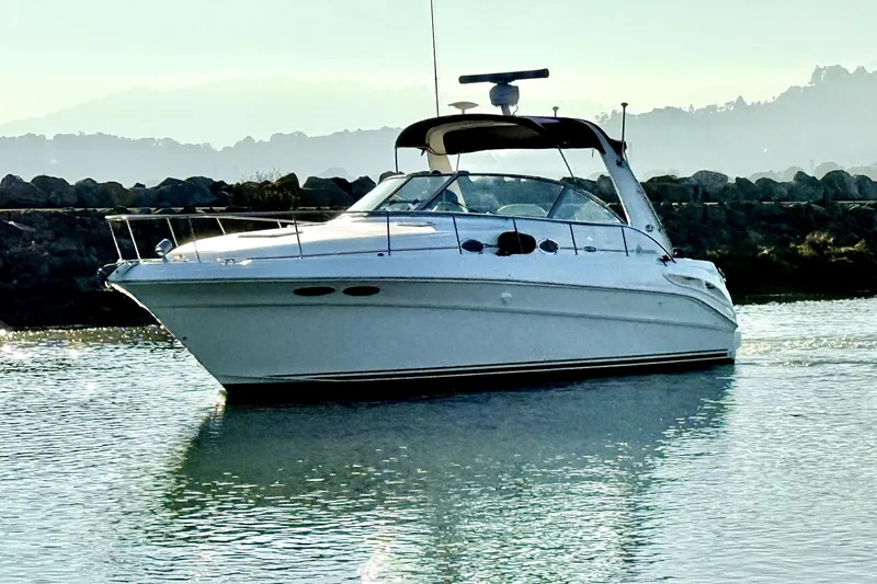 Slide: The Image of 2001 Sea Ray 340 Sundancer yacht cruising on calm water with scenic background. - 5