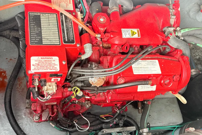 Slide: The Image of Engine of a 2001 Sea Ray 340 Sundancer boat, featuring red components and warning labels. - 29