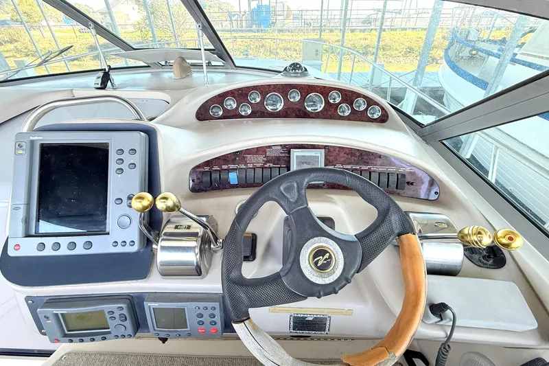Slide: The Image of Helm of 2001 Sea Ray 340 Sundancer with steering wheel and navigation controls. - 6