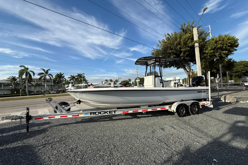 The Image of 2021 Contender 25 Bay boat on a Rocket trailer, parked outdoors under a clear sky. - 0