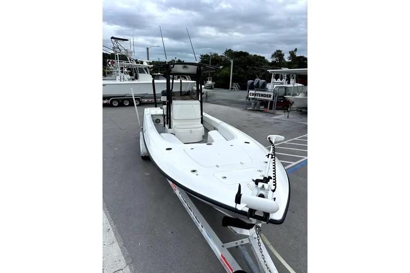 Slide: The Image of 2021 Contender 25 Bay boat interior with seating and speakers, parked on a sunny day. - 12